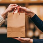 Handing off a shopping bag to a customer.