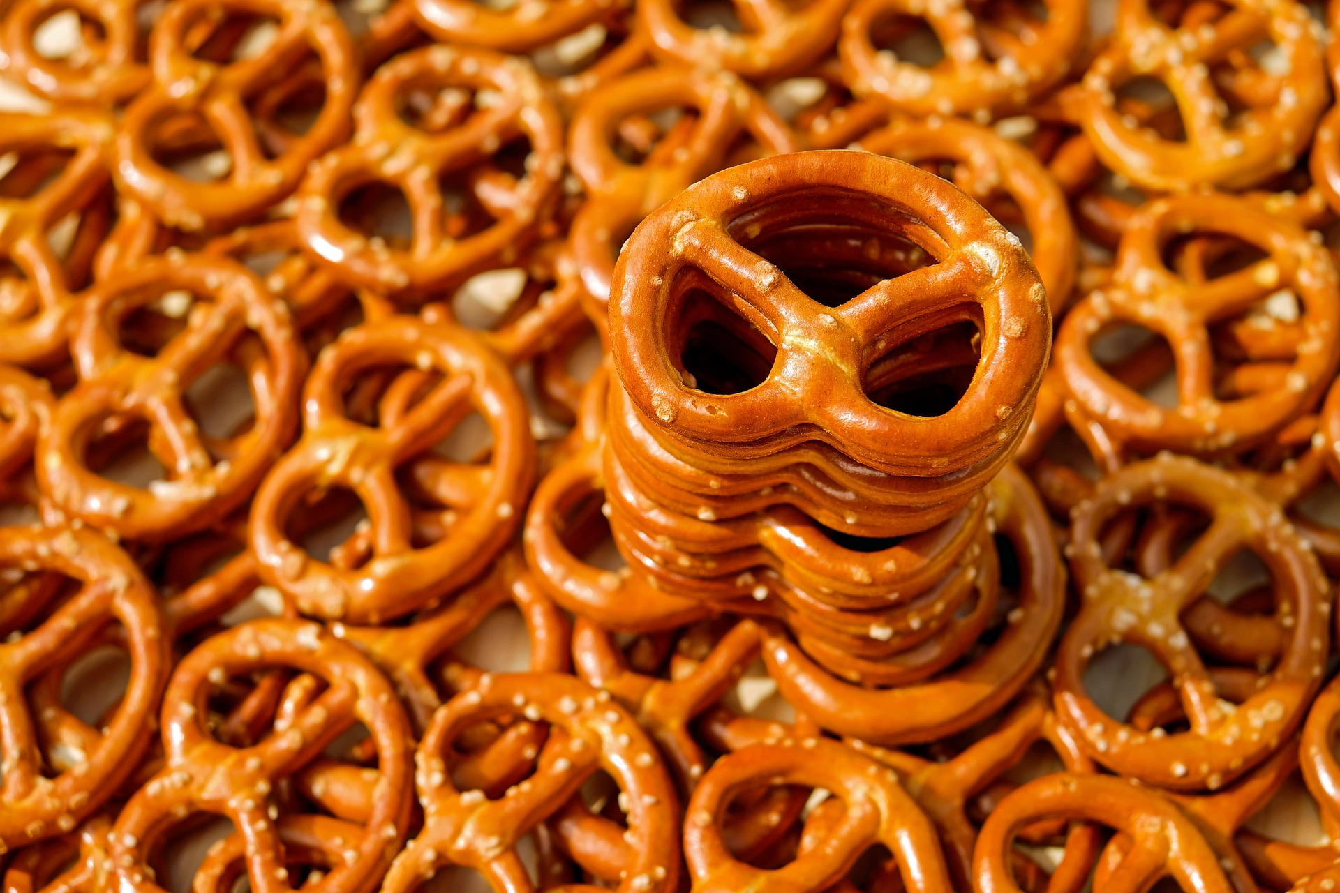 A bunch of snacking pretzels with a tower of them stacked.