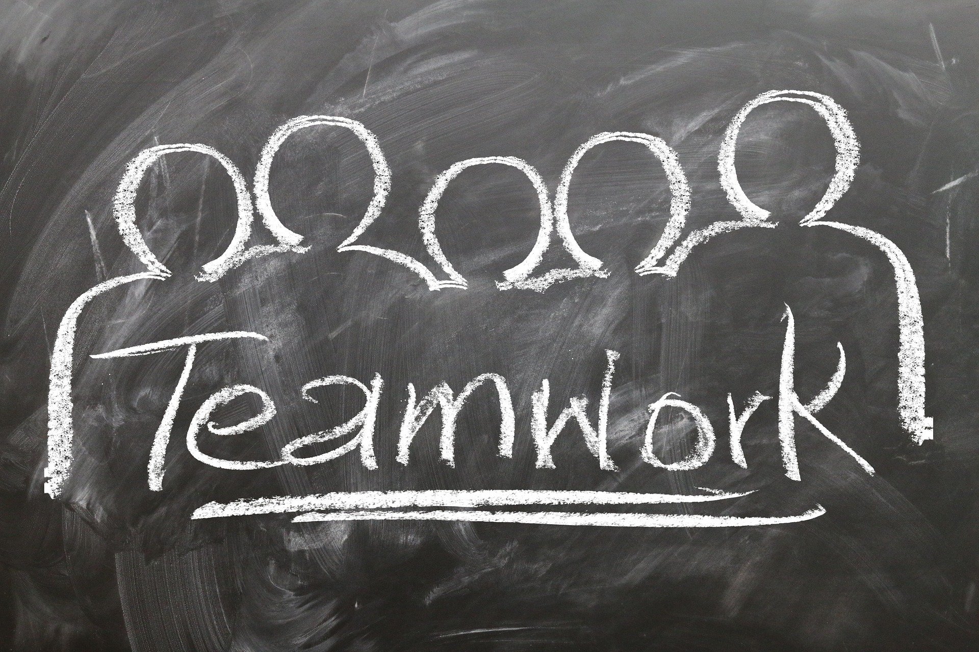 Chalkboard with people and Teamwork written across the board.
