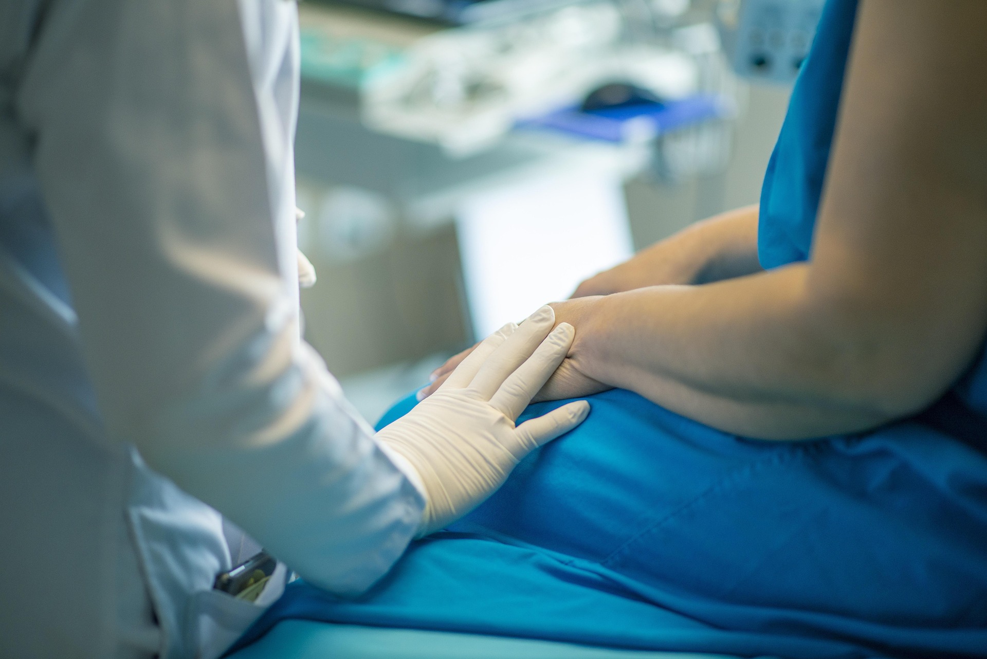 Nurse reassuring a patient with a touch on the arm.