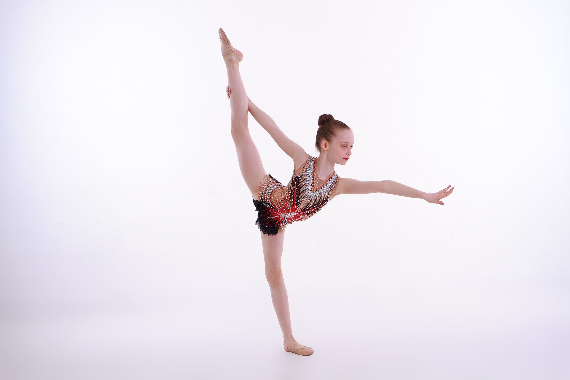 A young ballet dancer balancing on one foot.