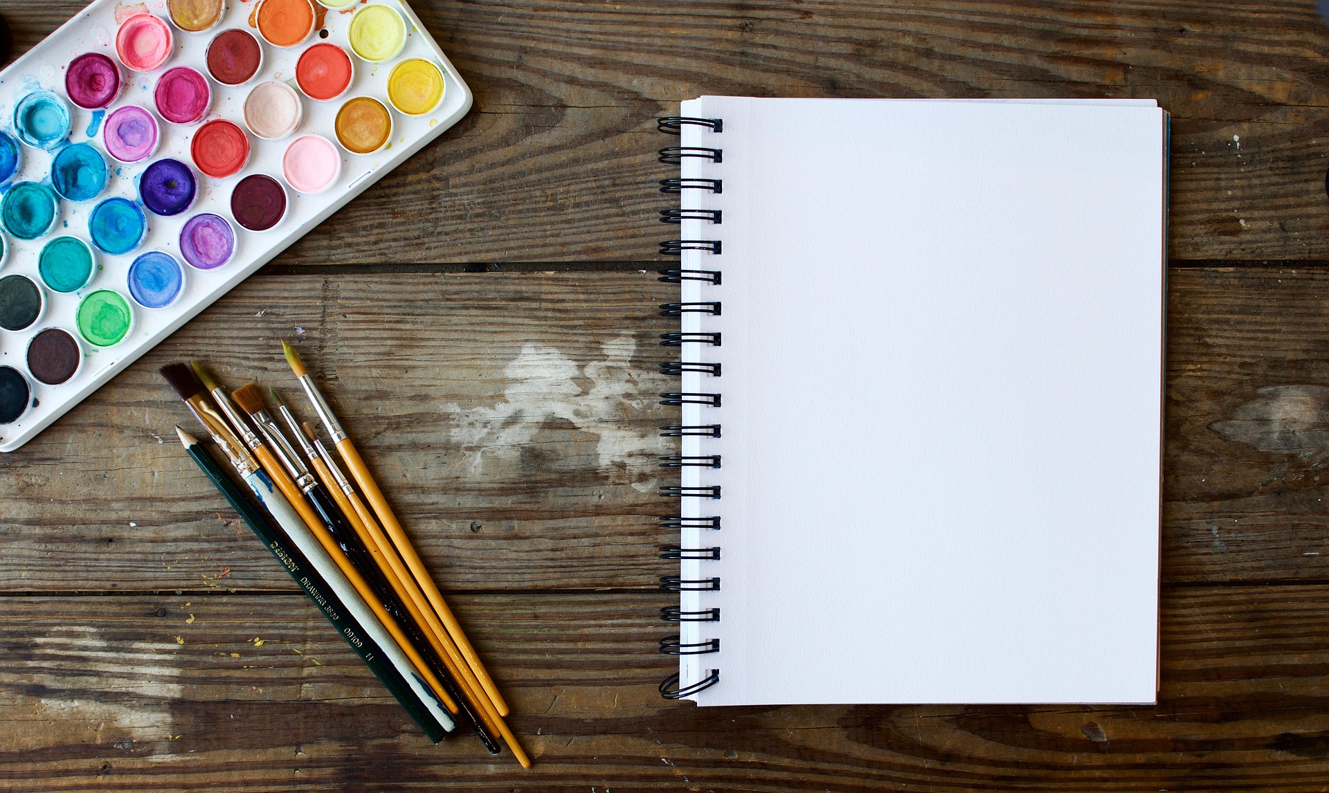 Watercolors with paintbrushes and sketch pad.