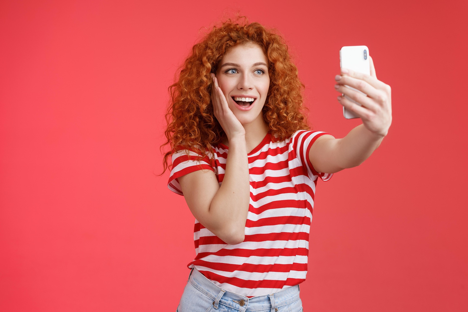 Generation Z young woman taking a selfie or viewing phone.