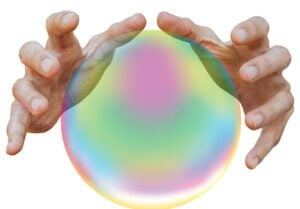 Two hands hovering over crystal ball.