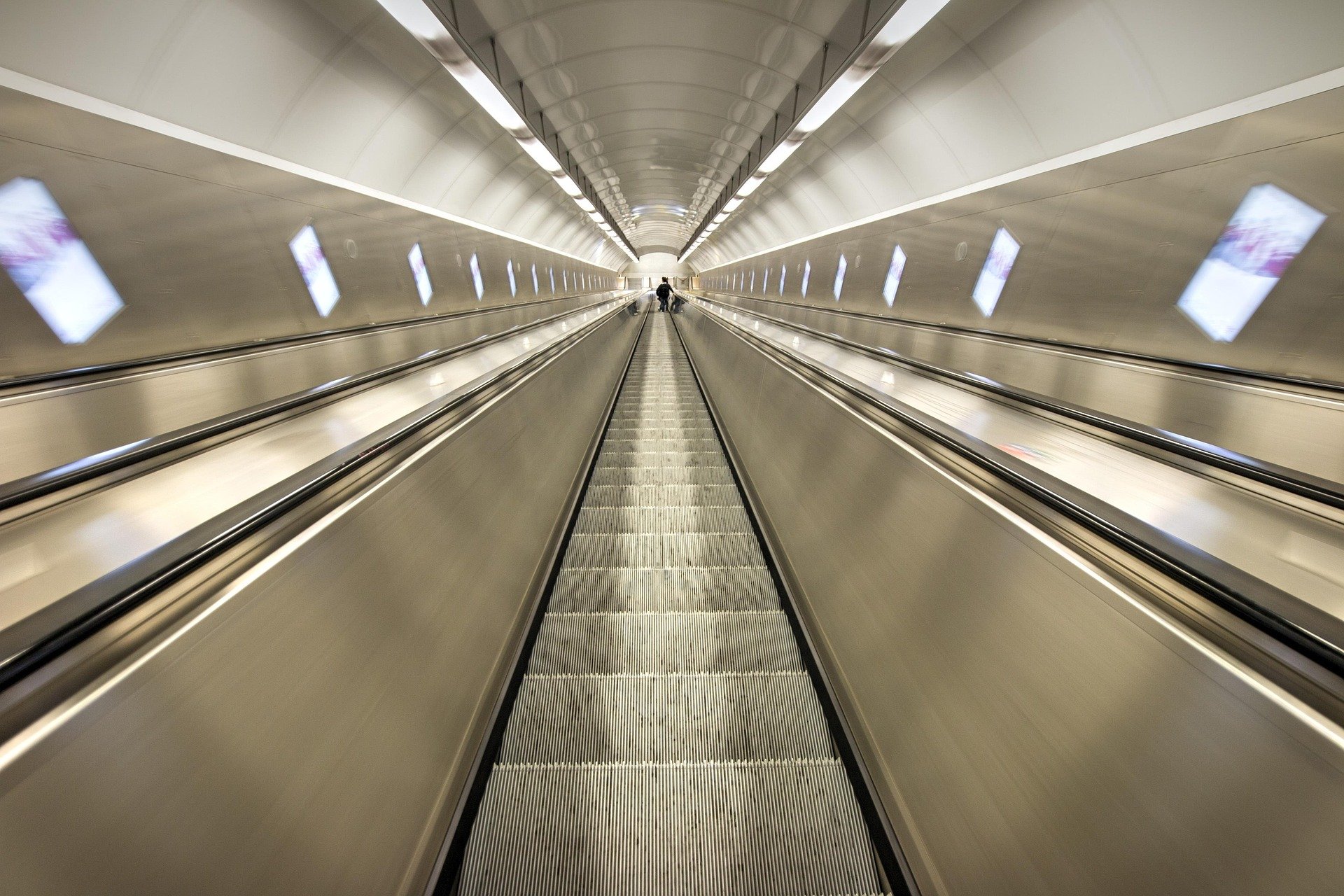 The perspective of going up or down a long escalator like in a subway.