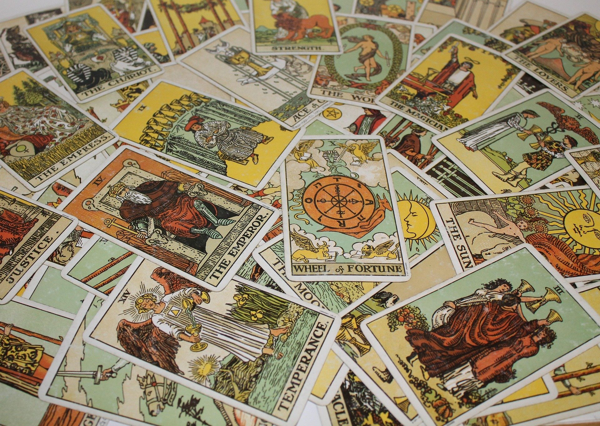 A variety of tarot cards spread out across a table.