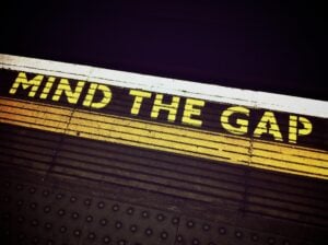 A 'Mind the Gap' sign on the floor of subway platform.