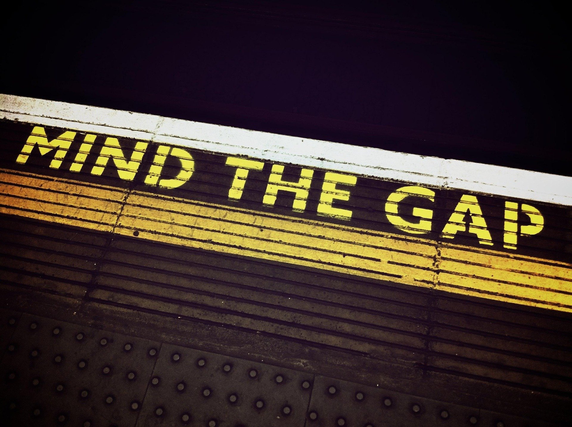 A 'Mind the Gap' sign on the floor of subway platform.