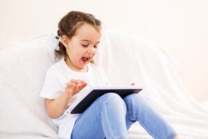 Young girl enjoying and watching a tablet device.