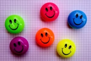 A colorful variety of smiley face candies or buttons.