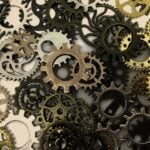 A pile of various different types and colors of cogs and gears from a machine.