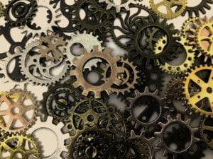 A pile of various different types and colors of cogs and gears from a machine.