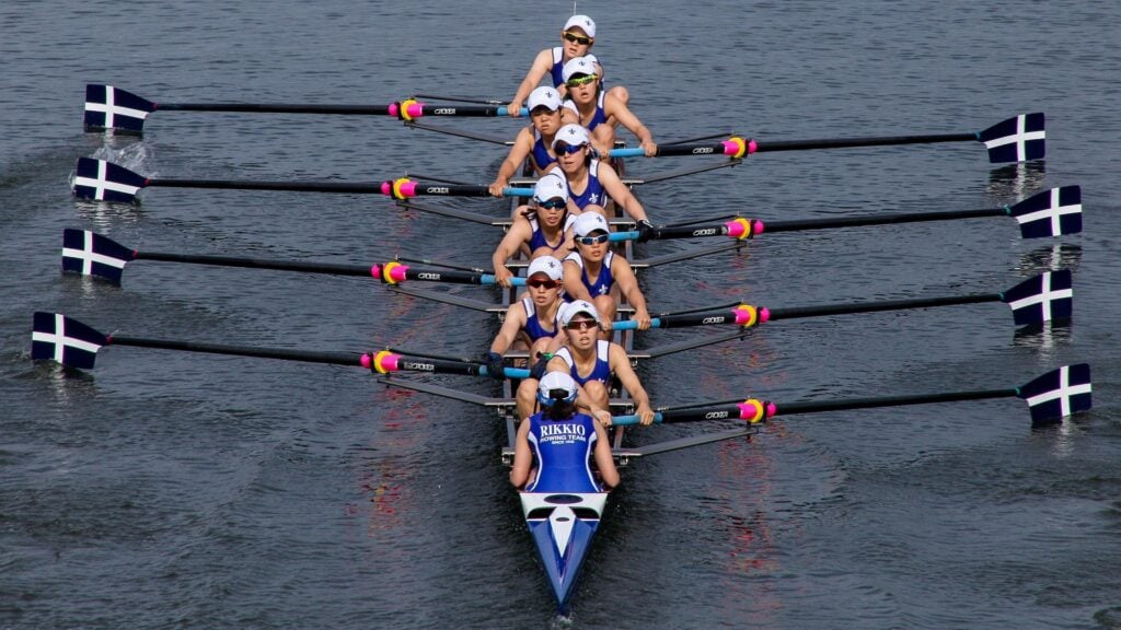 Competitive rowing team with paddles out and ready to row.