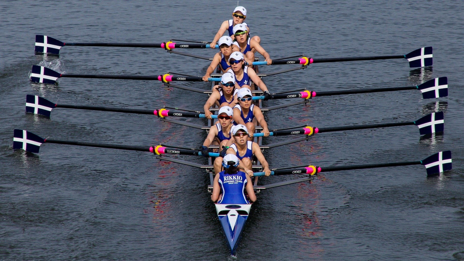 Competitive rowing team with paddles out and ready to row.