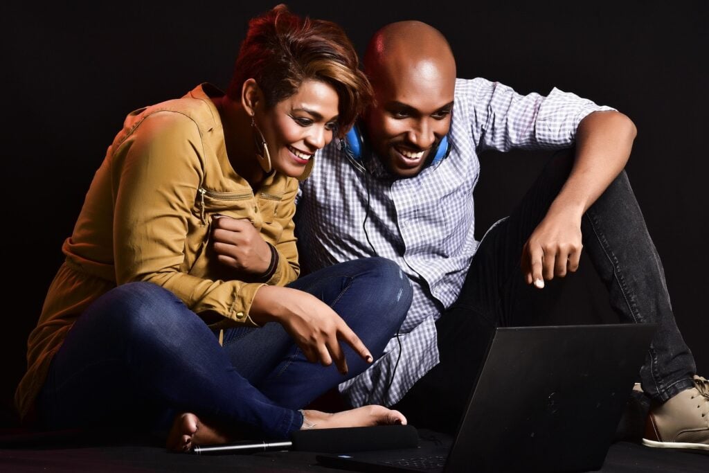 Black couple watching media on a laptop.