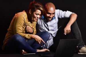 Black couple watching media on a laptop.