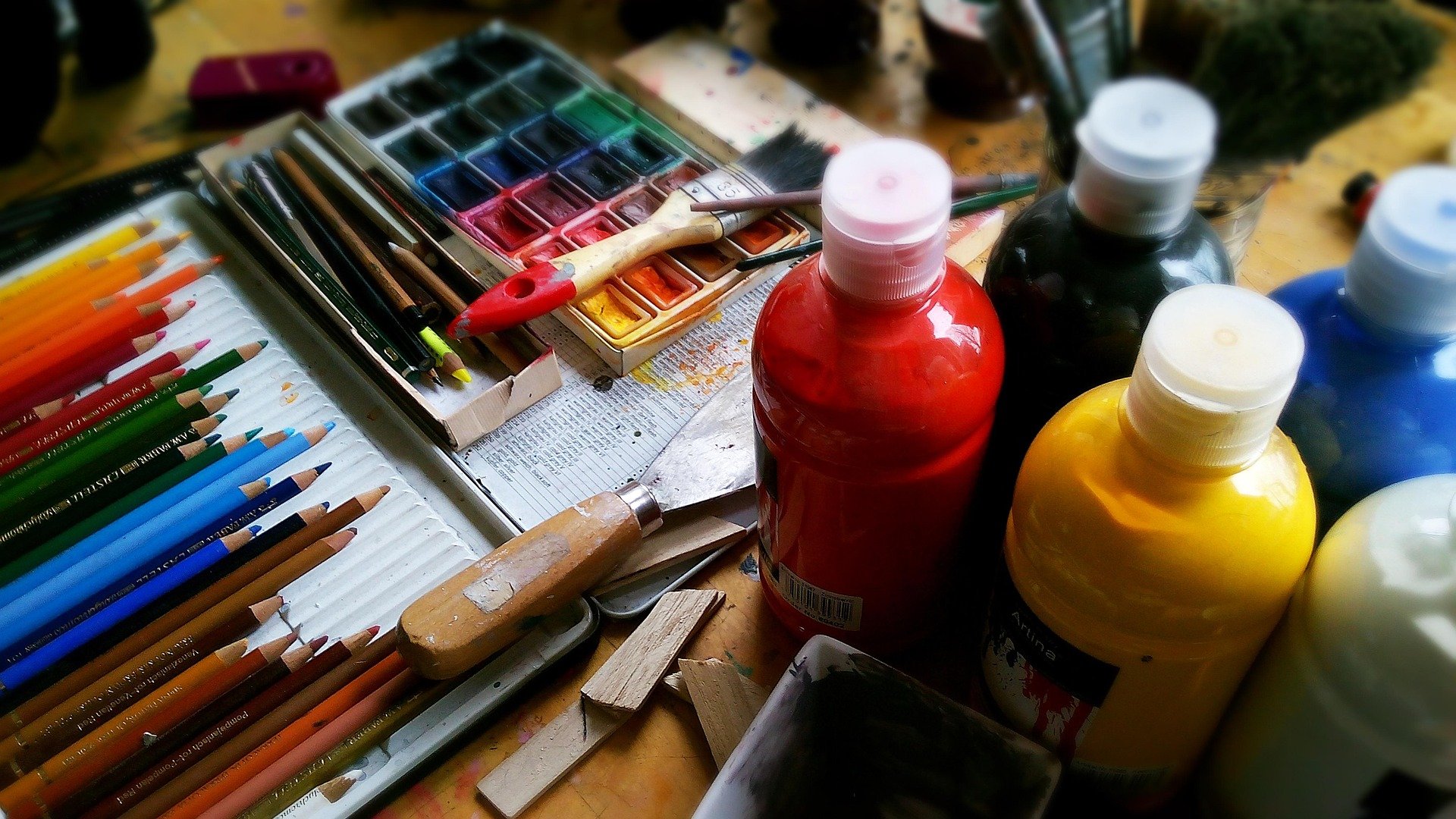 A mixed media palette of art and drawing/painting supplies.