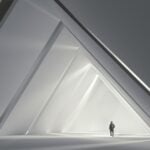 Triangle architecture playing off the TMRE graphics, with lone traveler going through the tunnel.