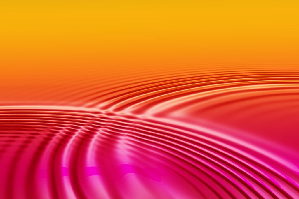 Concentric circles or waves/ripples of water on a light orangey background.