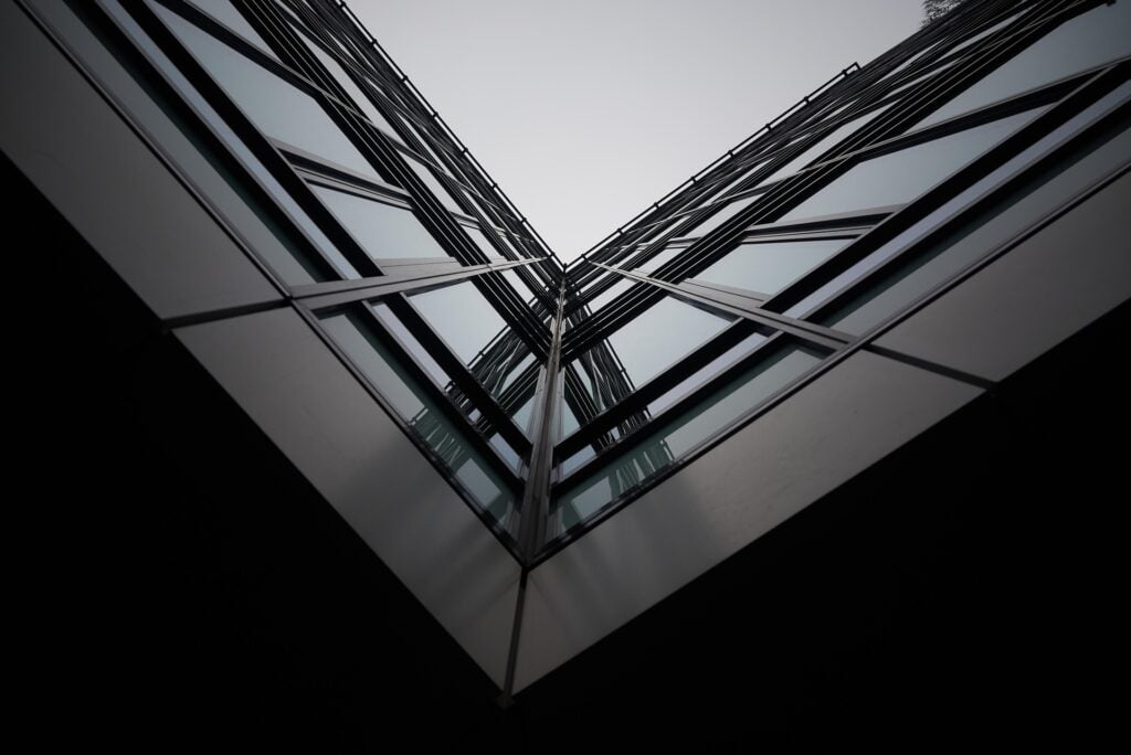 Interesting V angle/perspective looking up at an architectural glass building façade.