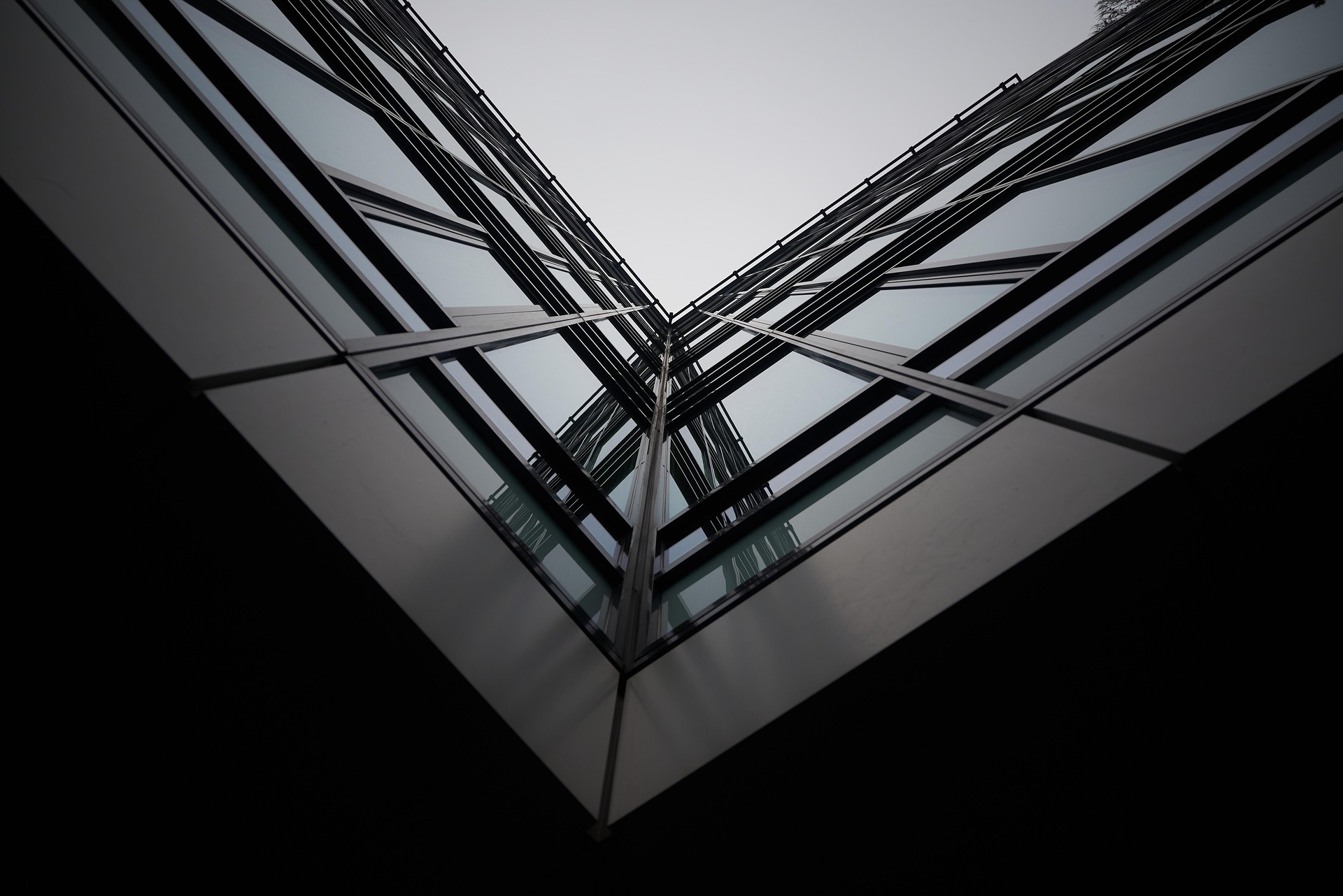 Interesting V angle/perspective looking up at an architectural glass building façade.
