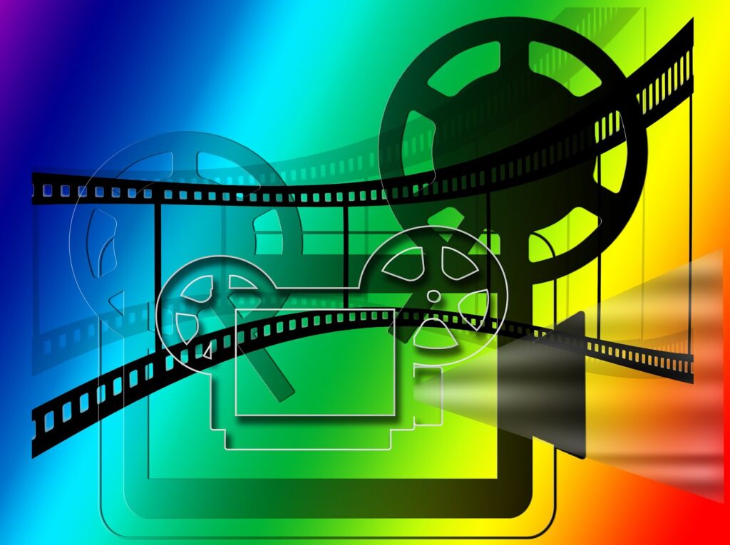 A stylized and colorful film projector graphic showing projector, film and reels.