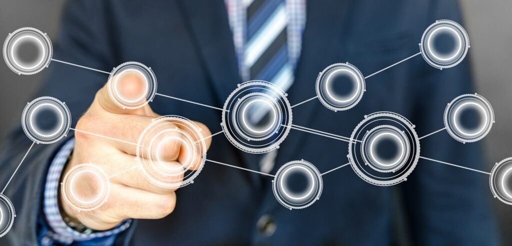 Businessman pressing a variety of virtual circular buttons on a wall screen.