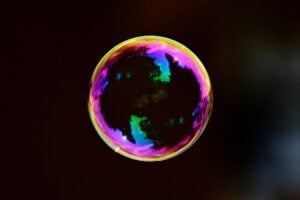 A colorful soap bubble rising into the air.