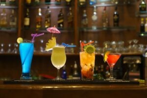 Four colorful drinks presented on a bar, each a unique cocktail experience.