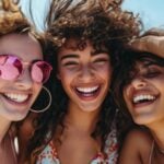 Three happy young girls hugging, smiling and laughing together.