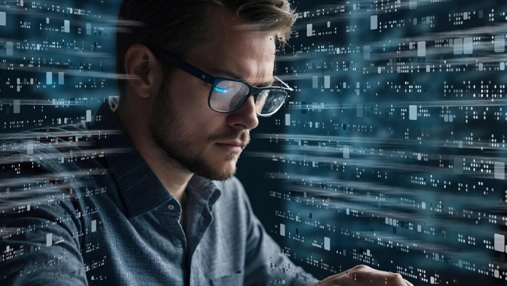 Businessman with glasses surrounded on all sides by data programming.