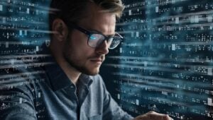 Businessman with glasses surrounded on all sides by data programming.