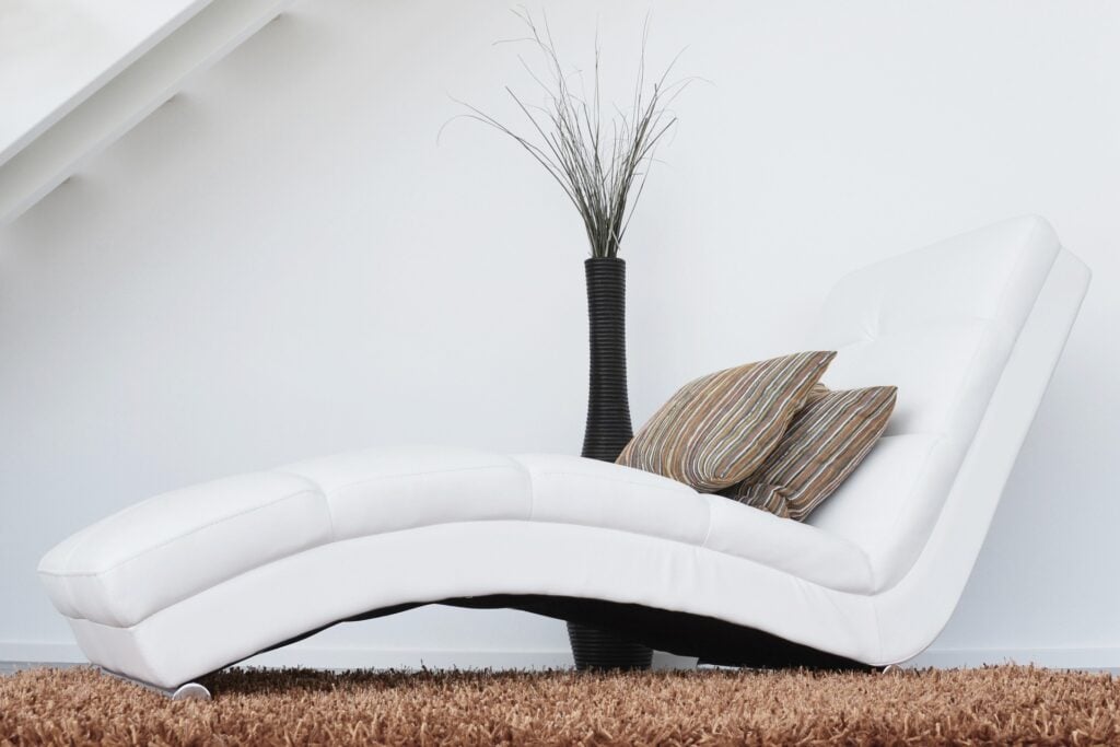 A curving luxury white couch with high end décor.