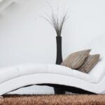 A curving luxury white couch with high end décor.