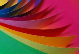 Swatches of colorful paper in a range of colors fanning outwards.