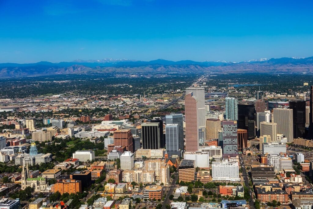 Downtown Denver skyline with Rocky Mountains in the background.
